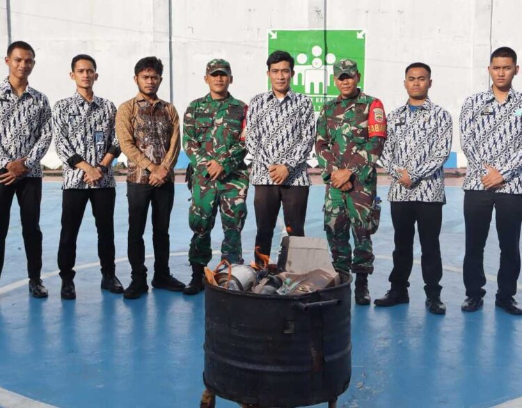 Tim gabungan dari Petugas Pengamanan Lapas Narkotika Pematangsiantar (berbatik) dan personel TNI dari Koramil 14/Raya (berseragam loreng) berpose di depan barang-barang sitaan yang berhasil diamankan dari razia dadakan.(Doc/Foto : Humas Lapas Raya)