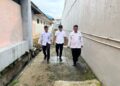 Kepala Urusan Umum (Kaur Umum) Lapas Kelas IIB Padangsidimpuan, Baginda Nauli Ritonga (paling kanan), bersama stafnya, melaksanakan pengecekan rutin kondisi fisik bangunan dan area drainase di jalur branggang Lapas.(Doc/Foto : Humas Lapassid)