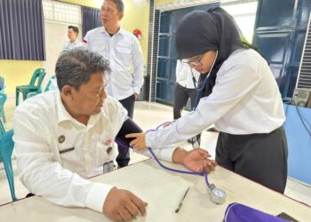 Kalapas Dede Mulyadi (kiri) menjalani pemeriksaan kesehatan dalam rangkaian kegiatan donor darah dan pengobatan gratis di Lapas Kelas IIB Tebing Tinggi.(Doc/Foto : Humas Lapas Tebing Tinggi)