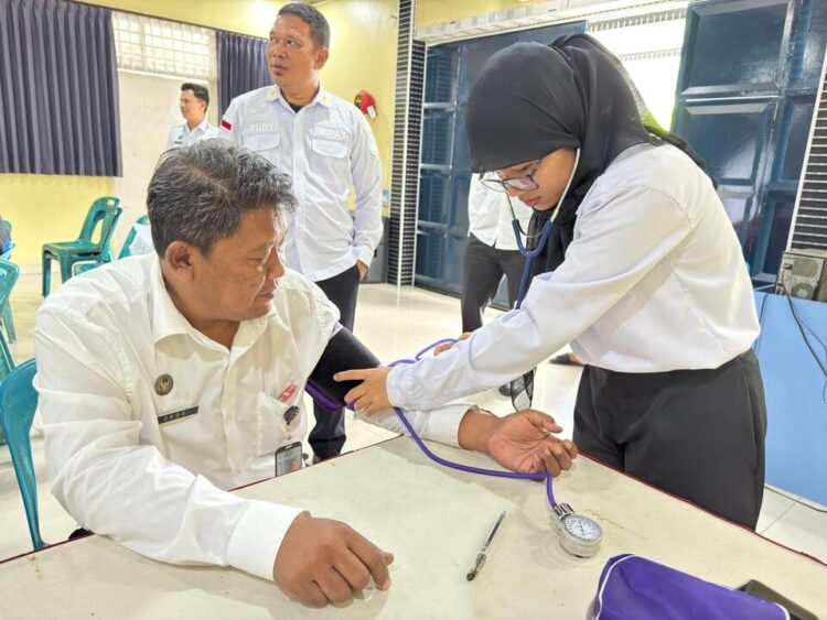 Kalapas Dede Mulyadi (kiri) menjalani pemeriksaan kesehatan dalam rangkaian kegiatan donor darah dan pengobatan gratis di Lapas Kelas IIB Tebing Tinggi.(Doc/Foto : Humas Lapas Tebing Tinggi)
