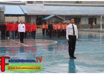 Petugas Lapas Kelas IIB Padangsidimpuan, berdiri tegap di tengah guyuran hujan, membacakan Teks UUD Tahun 1945 tanpa naskah saat Upacara Hari Bakti Kemenkumham ke-1.(Doc/Foto : Humas Lapassid)