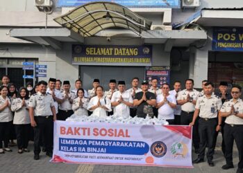 Jajaran petugas Lapas Kelas IIA Binjai berfoto bersama di depan spanduk kegiatan Bakti Sosial pembagian takjil. Mengusung semangat "Pemasyarakatan Pasti Bermanfaat Untuk Masyarakat".(Doc/Foto : Humas Lapas Binjai)